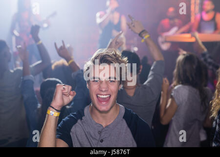 Porträt von glücklicher Mann stehend in Nachtclub Stockfoto