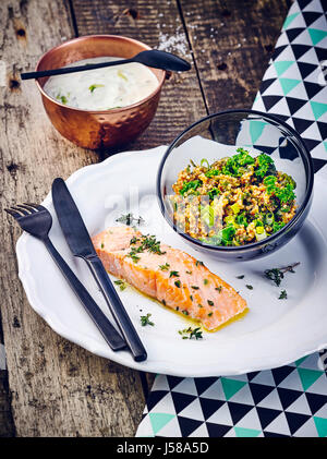 Gebackener Lachs mit Joghurt-Dip und Hirse-Salat mit Grünkohl Stockfoto