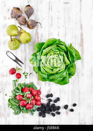 Verschiedene Arten von Obst und Gemüse auf hellen Holzoberfläche Stockfoto