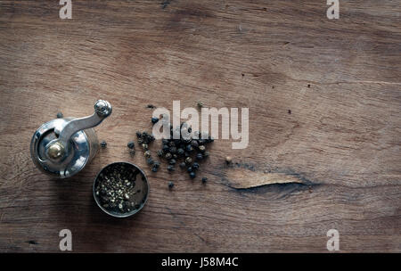 Alte Pfeffer Mühle und Pfefferkörner bilden Wort "Pfeffer" Stockfoto