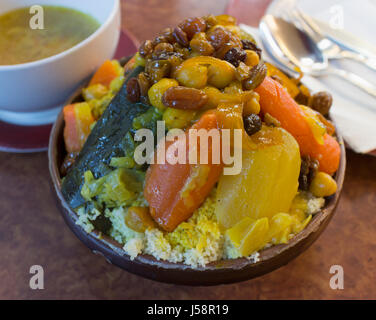 Hähnchen Couscous, eine typische nordafrikanische Speise. Links im Hintergrund Schüssel enthält die Brühe, die über den Couscous gekippt wird.  Abgesehen von Grieß ein Stockfoto
