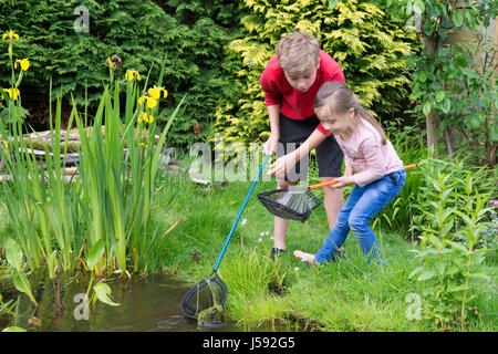 elf Jahre alten Jungen und vier Jahre altes Mädchen Teich eintauchen