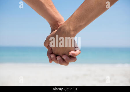 Hände des Paares, die Hand in Hand am Strand beschnitten Stockfoto