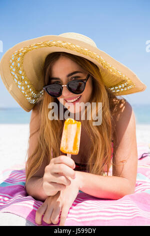 Porträt der Frau mit Eis am Stiel auf sonnigen Tag am Strand entspannen Stockfoto