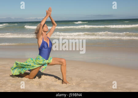 Volle Länge des senior Woman auf Sand am Strand erhobenen Armen Stockfoto