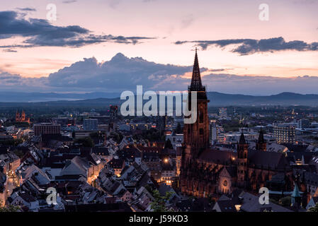 Blick auf den Sonnenuntergang von Freiburg im Breisgau mit dem Freiburger Münster (Kathedrale) im Vordergrund. Stockfoto