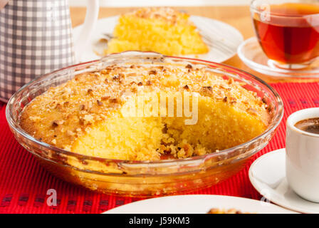 Shamali (Grieß Kuchen, Basbousa) auf weißen Tellern serviert, mit Kaffee und Tee Stockfoto