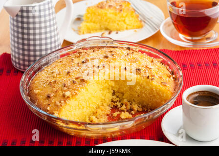 Shamali (Grieß Kuchen, Basbousa) auf weißen Tellern serviert, mit Kaffee und Tee Stockfoto