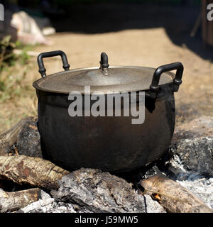 alten schwarzen Topf kochen am Lagerfeuer im freien Stockfoto