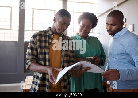 African Arbeitskollegen diskutieren Papierkram zusammen in einem modernen Büro Stockfoto