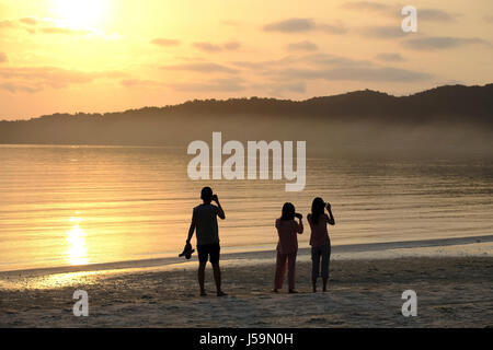 Touristen fotografieren eines Sonnenuntergangs. Asien, Südostasien, Kambodscha, Koh Rong Samloen Insel Stockfoto