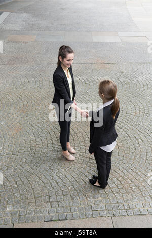 Erhöhten Blick auf zwei kaukasischen Geschäftsfrauen Händeschütteln. Stockfoto
