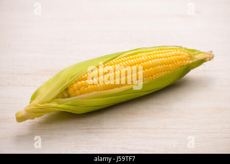 Süße Hühneraugen. Frischer Mais am Kolben auf hölzernen Tisch. Stockfoto