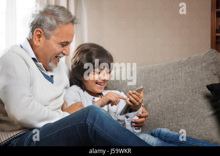 Glückliche Großvater und Enkel mit Handy Stockfoto