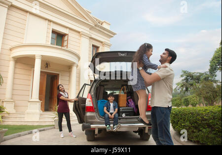 Familie im Freien stehen, mit dem Auto Vater heben Tochter Stockfoto