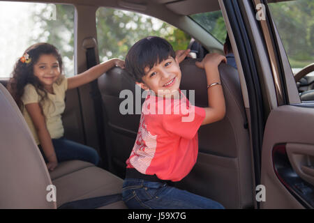 Süße junge und ein Mädchen sitzt auf dem Auto Rücksitz Stockfoto