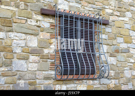 Fenster mit Eisengitter auf Steinmauer Stockfoto