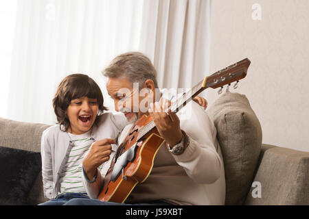 Großvater lehrt Enkel, Gitarre zu spielen Stockfoto