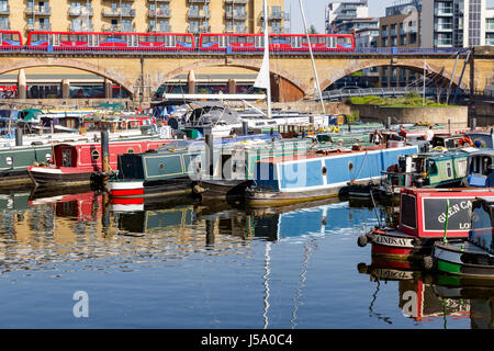 London, UK - 8. April 2017 - Schiffe und Jachten vor Anker in Limehouse Basin Marina mit der Docklands Light Railway vorbei in den Hintergrund Stockfoto