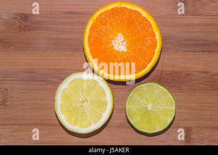 Eine Auswahl von gehackten Orange, Zitrone und Limette auf einem Holzbrett. Stockfoto