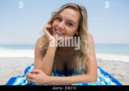 Porträt Frau mit Hand am Kinn entspannend am Strand gegen Himmel Stockfoto