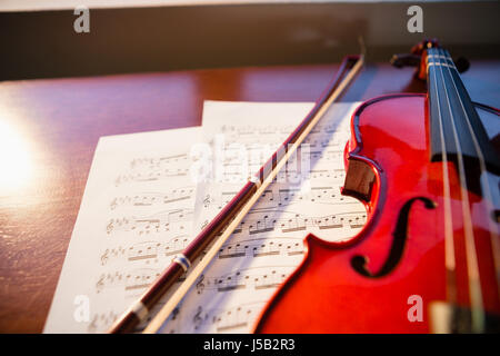 Erhöhte Ansicht der Violine mit Noten auf Tisch im Klassenzimmer Stockfoto