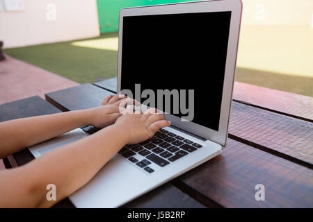 Nahaufnahme eines jungen mit digitalen Laptop sitzend am Tisch in der Schule Stockfoto