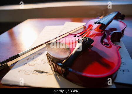 Nahaufnahme von Violine mit Noten auf Tisch im Klassenzimmer Stockfoto