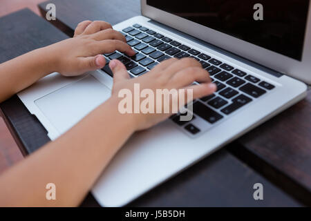 Bild mit digitalen Laptop sitzend am Tisch in der Schule Jungen beschnitten Stockfoto