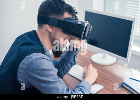 Jungunternehmer setzen auf Vr-Brille und lächelt Stockfoto