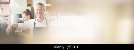 Lächelnd in die Kamera im Café Barista Stockfoto