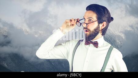 Digital Composite Shocked Hipster tragen Brillen gegen Berge Stockfoto