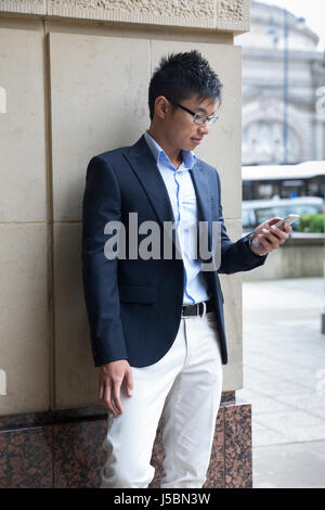 Chinageschäft Mann mit seinem Smartphone im Freien in modernen Stadt. Stockfoto