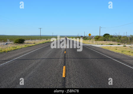 U.S. Highway 385 auf dem Weg zum Big Bend National Park erstreckt sich lang und Meerenge in die Ferne von Fort Stockton, Texas Stockfoto