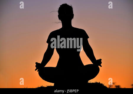 Silhouette des jungen Mädchens im Ardha Padmasana Lotus darstellen, in der Nähe von Berg, Pune, Maharashtra Stockfoto