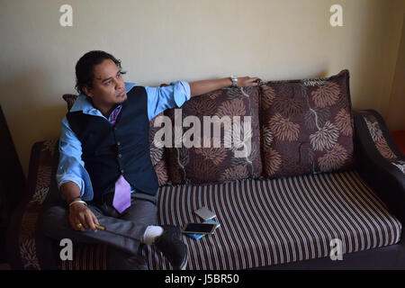 Junger Mann sitzt auf dem Sofa, Pune, Maharashtra Stockfoto