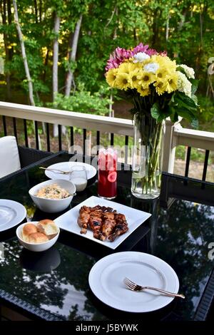 Außengastronomie mit BBQ Chicken Drumsticks, Abendessen Brötchen, Nudelsalat, und Eistee Stockfoto