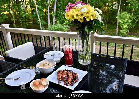 Außengastronomie mit BBQ Chicken Drumsticks, Abendessen Brötchen, Nudelsalat, und Eistee Stockfoto