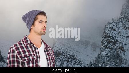 Digital Composite junge Hipster tragen stricken Hut vor schneebedeckten Bergen Stockfoto