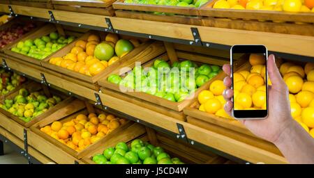 Digital Composite Hand fotografieren, Obst und Gemüse auf Smartphone im store Stockfoto