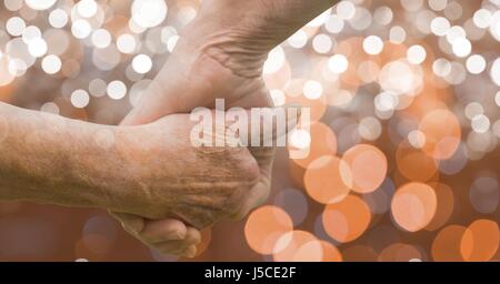 Digitalen Verbund aus Close-up älteres paar Holding übergibt bokeh Stockfoto