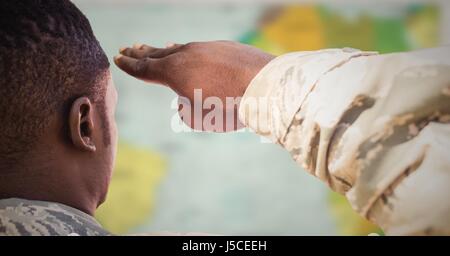 Digitalen Verbund aus Rückseite Soldaten salutieren gegen verschwommen Karte Stockfoto