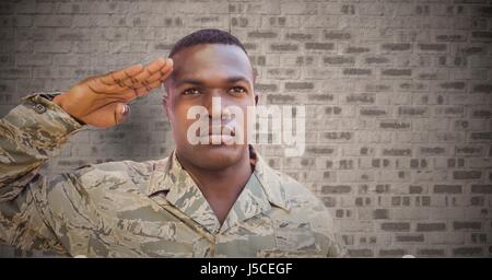 Digital Composite Soldaten salutieren gegen braune Ziegelwand Stockfoto