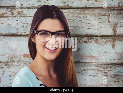Digital Composite Porträt glücklich Frau mit Brille gegen Holzwand Stockfoto