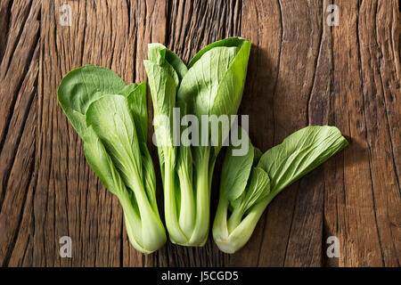 Bok Choy oder Pak Choi sitzen auf einem rustikalen hölzernen Hintergrund. Stockfoto