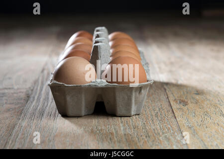 Karton frische Landeier auf rustikalen Tisch sitzen. Stockfoto