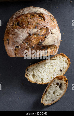 Brotlaib auf schwarzen Schiefer Brett geschnitten. Stockfoto