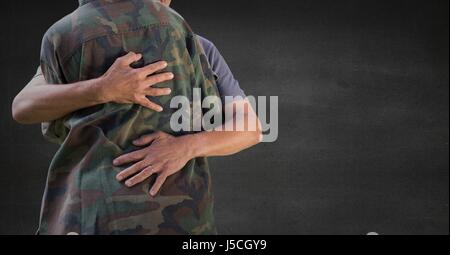 Digitalen Verbund aus Rückseite Soldat umarmt gegen graue Wand Stockfoto