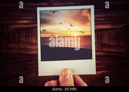 Polaroid-Postkarte von wunderschönen Sonnenuntergang über Meer Küste mit Vogel-Silhouetten und Wolken. Reise-Erinnerungen-Scrapbooking-Vorlage mit Textfreiraum Stockfoto