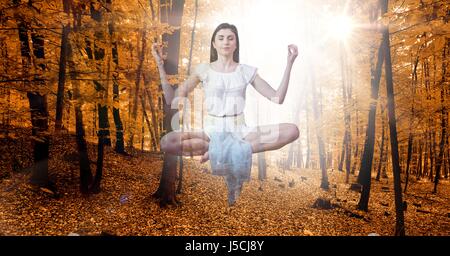 Digital Composite Doppelbelichtung Frau meditieren in der Luft im herbstlichen Wald Stockfoto